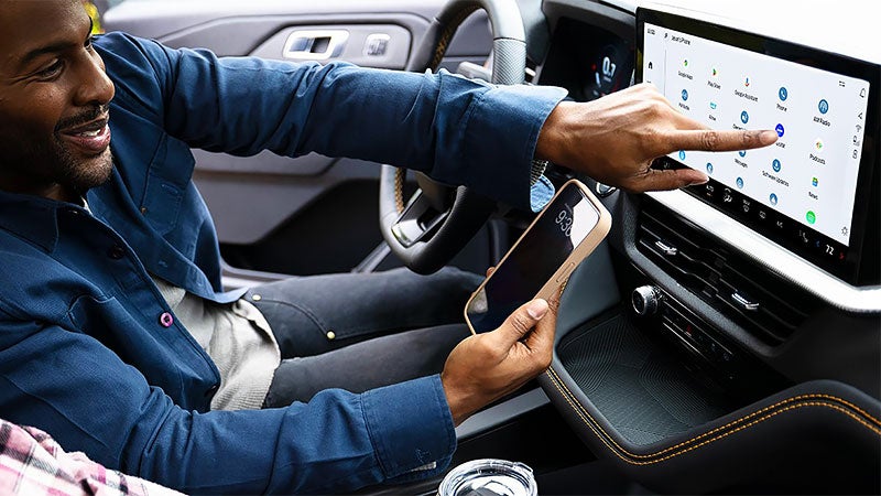 Driver in a 2027 Ford Explorer Tremor using wireless smartphone integration on the 13.2-inch Ford Digital Experience display