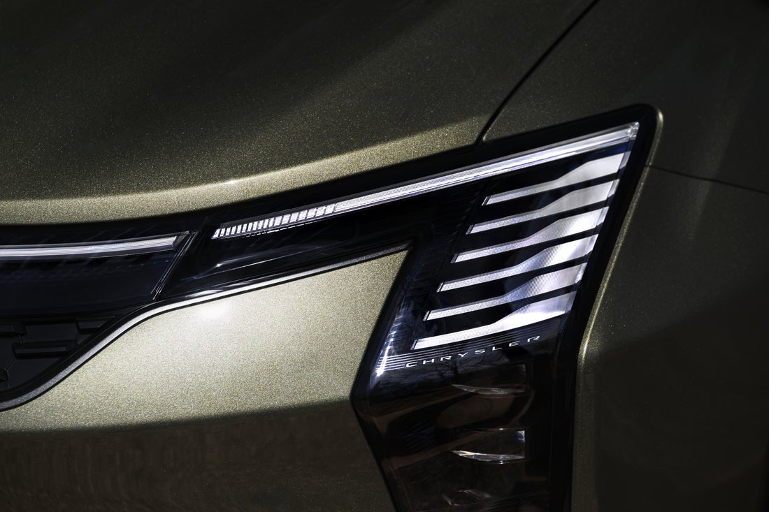 2027 Chrysler Pacifica in Olive Green close-up of vertical projector LED headlamp and piano-key lighting signature