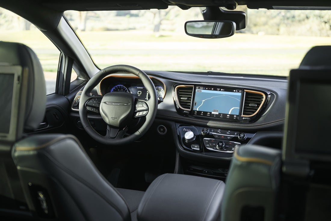 2027 Chrysler Pacifica Pinnacle cockpit showing 10.1-inch Uconnect 5 touchscreen, Copper Alloy bezels, heated steering wheel, and rotary e-Flite shifter